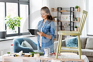 woman with tablet pc and old chair for renovation