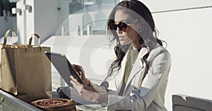 Woman, tablet and shopping bag in city for online sale, discount and fashion newsletter in park or outdoor. Person
