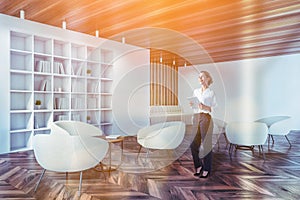 Woman with tablet in white living room corner