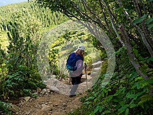 Woman tackling the steep and rugged descent from top of the mountain