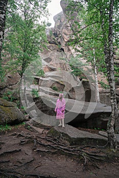 Woman in the taiga forest and rocks of the Stolby nature reserve park