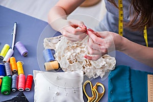 Woman tailor working on a clothing sewing stitching measuring fa