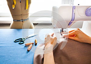 Woman tailor working on sewing machine. Hands. close up. Tailoring. Details.