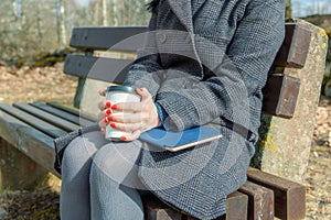 Woman with take away cup of coffee and tablet