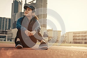 A woman take a break from running outdoor and workout on track race at stadium and sunset