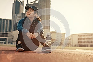 A woman take a break from running outdoor and workout on track race at stadium and sunset photo