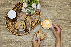 woman take her breakfast, Latte art on hot latte coffee with homemade chocolate chip cookies with honey jar