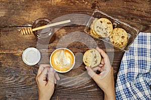 woman take her breakfast, Latte art on hot latte coffee with homemade chocolate chip cookies with honey jar