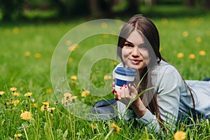 Woman with takeaway drink in park