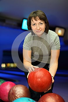 Woman takes ball for playing in bowling