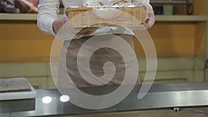 Woman takes box with bake from the show case