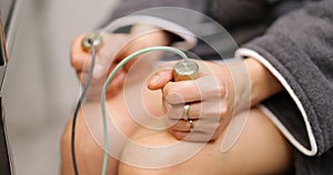 Woman takes hold of the brass handpieces of bioenergetic testing device