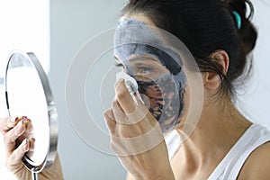 Woman takes off her anti-aging face mask