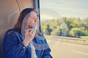 Woman takes off medical mask in public transport. A female tourist took off her face mask on a bus