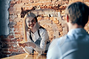 a woman takes an order from a man in a cafe serving a waiter