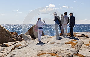 Woman takes photo of a family at Bingi Bingi point. NSW. Australia