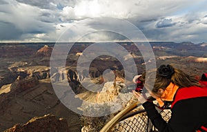 Woman takes photograph of Grand Canyon