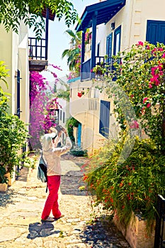 Woman takes picture of picturesque house on the street of Kalkan in Turkey