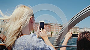 A woman takes pictures of Copenhagen's sights, sails on the excursion ship through the city's canals