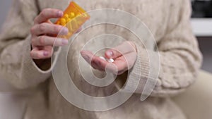 Woman takes pills. Woman pours pills into the palm of her hand and takes tablets