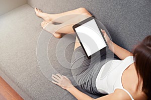 Woman takes a rest with tablet, on sofa