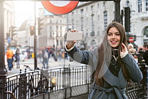 Woman takes selfie pictures at Piccadilly Circus in Central London, UK photo