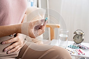 Woman taking antibiotic pill to treat bacterial , urinary tract infections photo