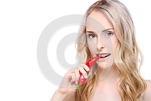 Woman taking bite of chili pepper