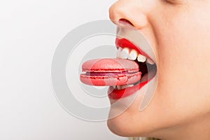 Woman taking a bite of pink macaroon