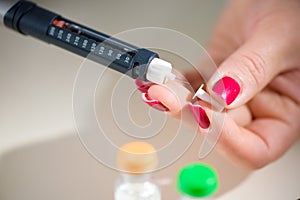 Woman taking blood sample with lancet pen. Diabetes.