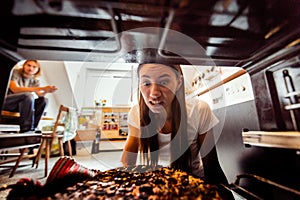 Woman Taking Burnt Pizza From Stove