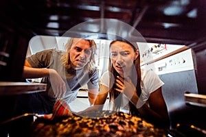 Woman Taking Burnt Pizza From Stove