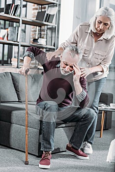 Woman taking care of husband with strong headache at home