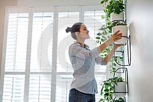 Woman taking care of the plants at her apartment