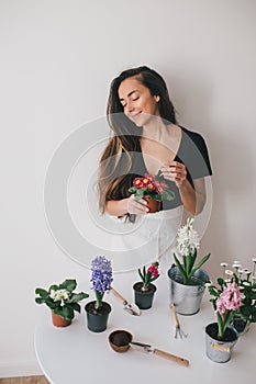 Woman taking care for plants and home flowers.