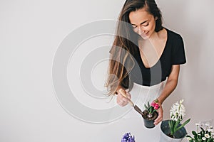 Woman taking care for plants and home flowers.