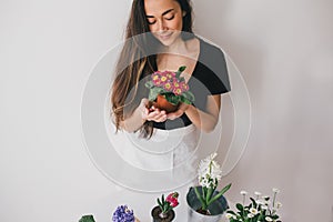 Woman taking care for plants and home flowers.