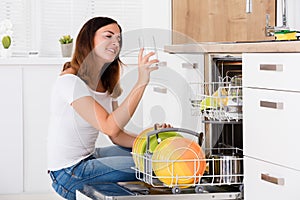 Woman Taking Drinking Glass From Dishwasher