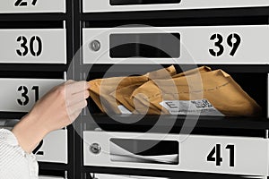 Woman taking envelope out of mailbox, closeup