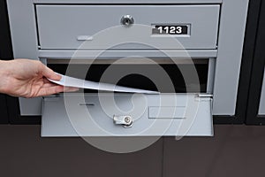 Woman taking envelopes out from mailbox indoors, closeup