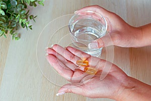 Woman taking fishtail food supplements for diet.