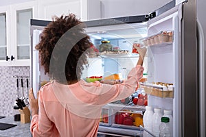 Woman Taking Food From Refrigerator