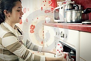 Woman taking frying pan from oven