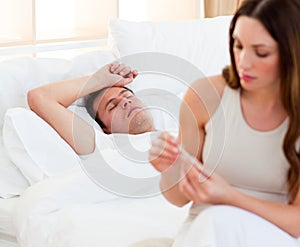 Woman taking her sick husband's temperature