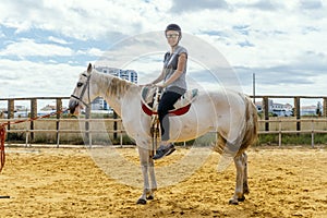 A woman taking horse riding lessons in a paddock