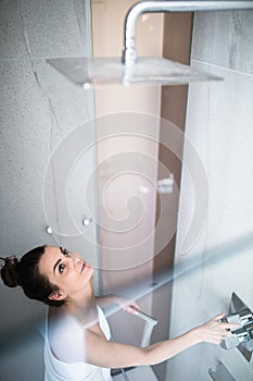 Woman taking a long hot shower washing her hair