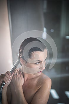 Woman taking a long hot shower washing her hair