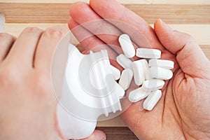 Woman taking magnesium pills out of a bottle