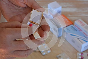 Woman taking medication from a pill box