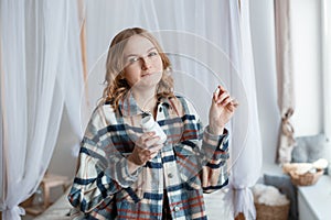 Woman Taking Medicine. Beautiful blond girl taking Medication, Holding Bottle With Pills In Hand. Diet. Nutrition